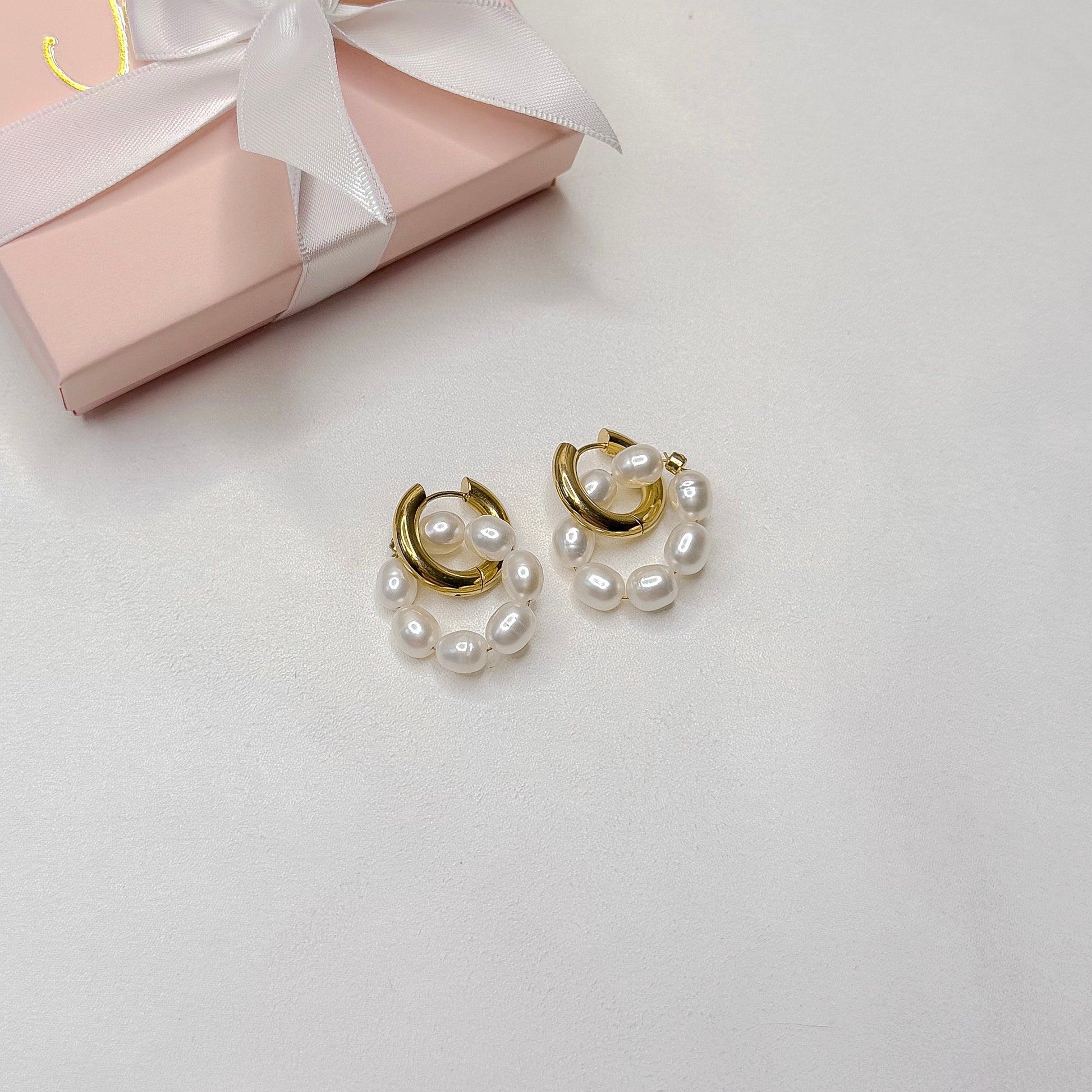 minimalist pearl hoop earrings with interchangeable charms flat lay